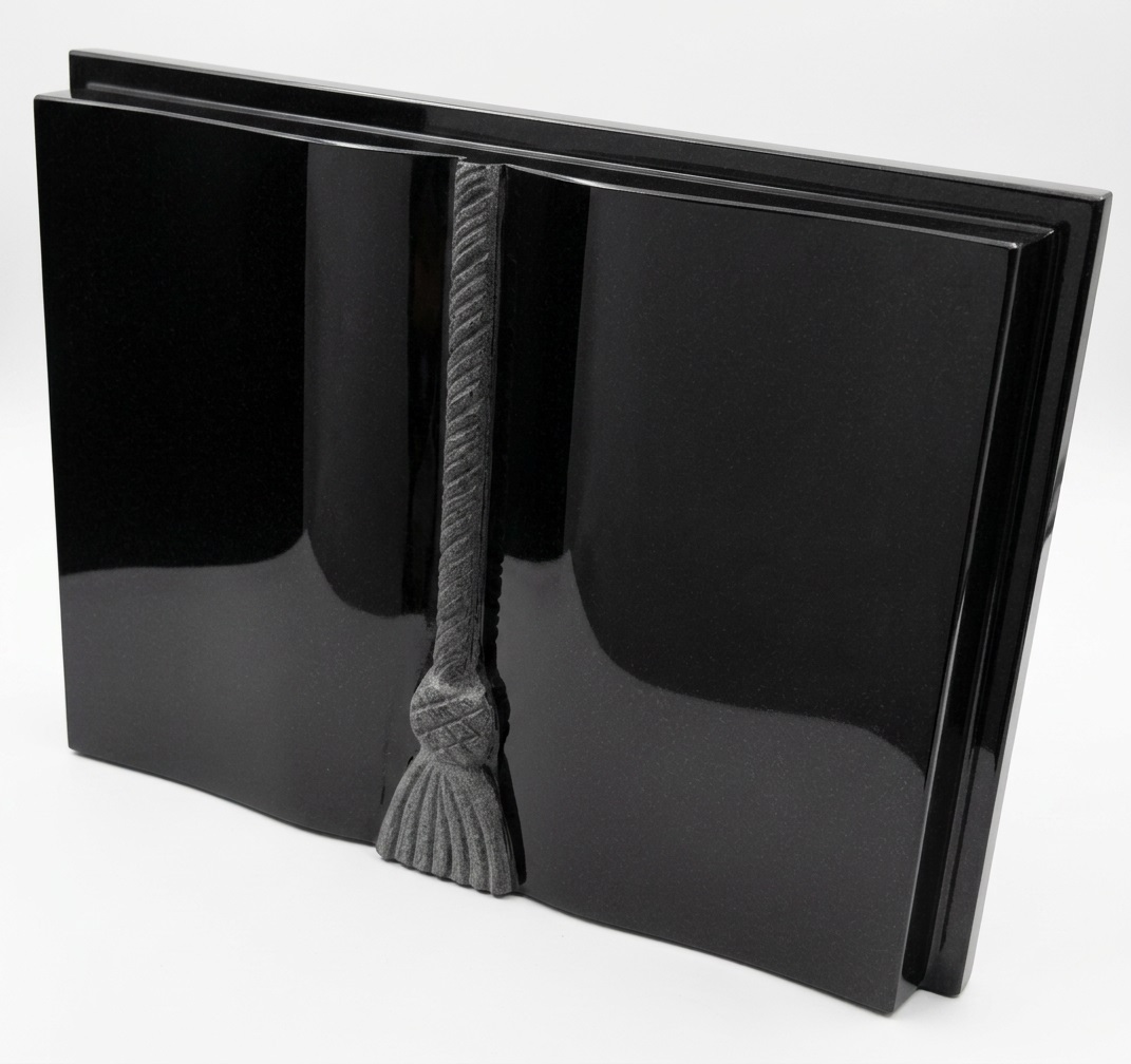 Black granite upright open book memorial with carved cord and tassel detail on tapered riser