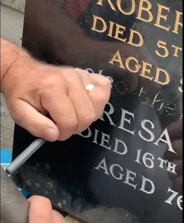 Red rose resting on a memorial stone